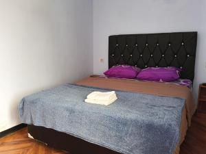a bedroom with a bed with purple pillows at Den Bagus Bromo in Ngadisari
