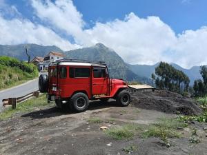 a red jeep parked on the side of a road at Den Bagus Bromo in Ngadisari