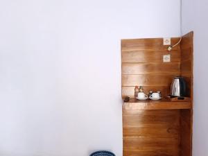 a kitchen with a wooden shelf with pots and pans at Den Bagus Bromo in Ngadisari +14 photos
