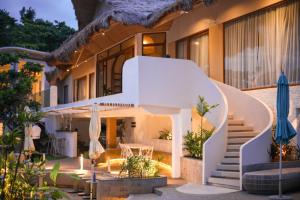 a villa with a staircase leading up to a house at Solea Reef Resort Anda in Anda