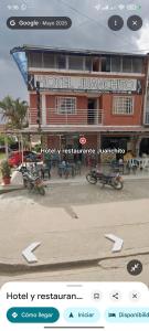 a hotel with tables and chairs in front of a building at Hotel y restaurante juanchito in Pitalito