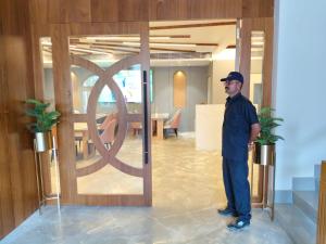 a man standing in front of a door in a room at Ira by Orchid Dwarka in Dwarka