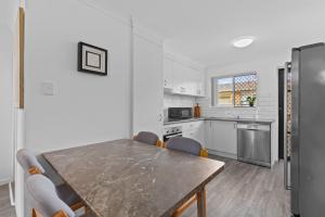 Una cocina con una mesa y sillas en una habitación. en Central, Comfortable, Convenient - CCC, en Pialba