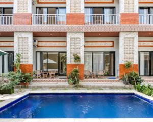 a building with a swimming pool in front of a building at Dhita Kubu in Kerobokan