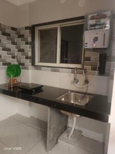 eine Badezimmerablage mit Waschbecken und Spiegel in der Unterkunft Sai palace inn 2 bhk furnished flat in Dāpuri