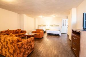 una sala de estar con un sofá y una cama en Hotel Argento Zacatecas, en Zacatecas