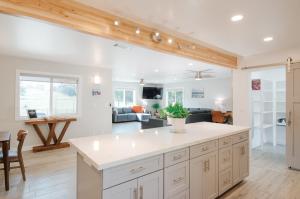 a kitchen with white cabinets and a living room at Dennison House in Three Rivers