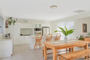 a kitchen and dining room with a wooden table and chairs at Black Rocks Hideaway - 3BR Beach Home by uHoliday in Pottsville