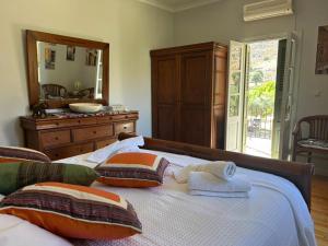 a bedroom with a bed with pillows and a mirror at Villa To Petrino in Vathís