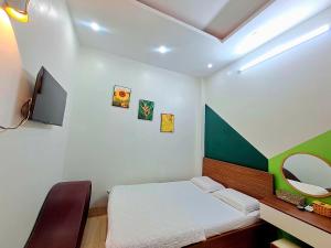 a small bedroom with a bed and a mirror at Motel TRUNG HẬU in Ấp An Mỹ