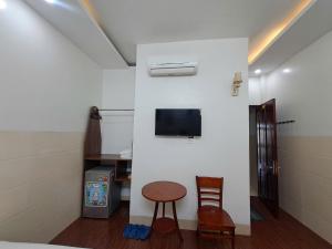a room with a table and a tv on a wall at Motel TRUNG HẬU in Ấp An Mỹ