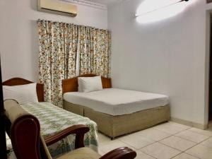 a bedroom with two beds and a window with a curtain at Maya Eco Guest House in Dhaka +20 photos