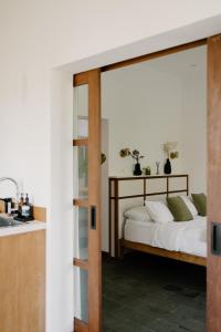 a bedroom with a bed with white sheets and a sink at The Birdhouse Uluwatu 2BR Treetop Private Home with Deep Plunge Pool in Uluwatu