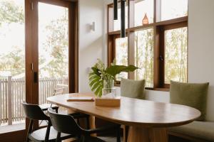 a dining room with a wooden table and chairs at The Birdhouse Uluwatu 2BR Treetop Private Home with Deep Plunge Pool in Uluwatu