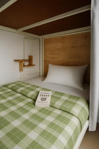 a bed with a sign sitting on top of it at Green Sleep Hostel in Chiang Mai