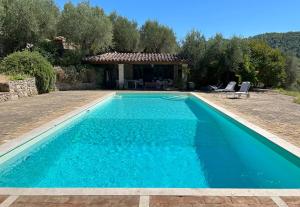 a swimming pool with blue water in front of a house at Casale Greppobello in Perugia