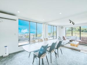 een witte eetkamer met een tafel en stoelen bij Awaji Nature Retreat in Awaji