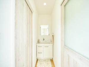 een witte badkamer met een wastafel en een spiegel bij Awaji Nature Retreat in Awaji +38 foto's