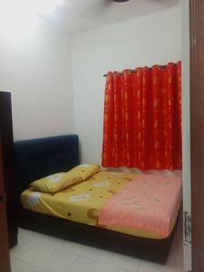 a bed in a room with red curtains at Homestay Saadiah in Sungai Besar +10 photos