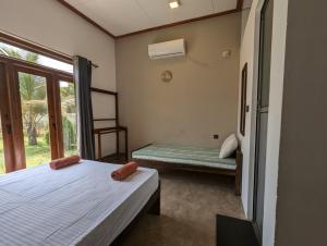 a bedroom with two beds and a window at Aiden Homestay in Pasikuda