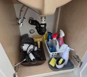 a kitchen cabinet with a sink and some dishes at New Langford Suite near Lake & Mall, Free Parking in Goldstream Station