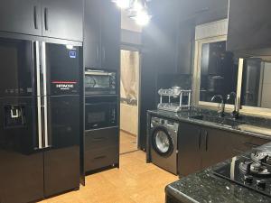 a kitchen with a refrigerator and a washer and dryer at Modern 3BR Sea & Mountain View Apartment Bouar, Keserwan in Bqāq ad Dīn