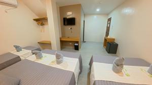 een kamer met 2 bedden en een tv. bij NINIE'S PLACE in Puerto Princesa City