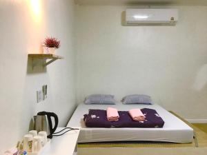 a bedroom with a bed with two pink towels on it at Daddy's homestay in Ban Bang Krasan