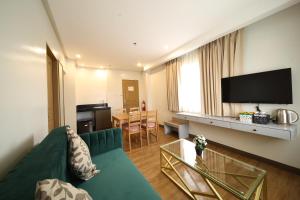 uma sala de estar com um sofá verde e uma televisão de ecrã plano em Via Appia Tagaytay em Tagaytay