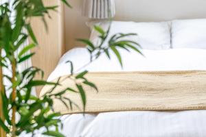een slaapkamer met een wit bed met 2 planten bij SG Hotel Kinshai Hakata in Fukuoka