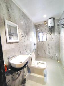 a bathroom with a white toilet and a sink at Happy Villa Regency in Guwahati