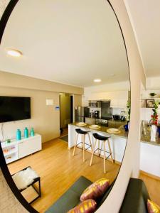 a living room with a mirror and a kitchen at San Miguel Apartment Vista Mar in Lima