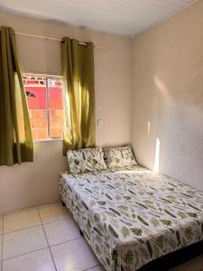 Un dormitorio pequeño con una cama y una ventana. en Refujo Ideal em Família, en Prado