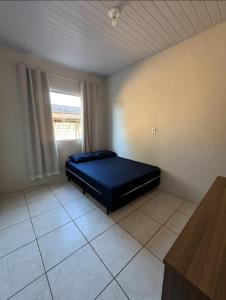 Un dormitorio con una cama en una habitación con ventana. en Refujo Ideal em Família, en Prado