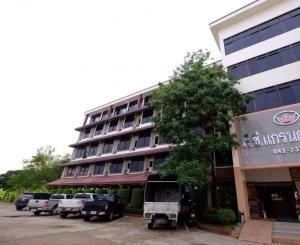 un grand bâtiment avec des voitures garées devant dans l'établissement PC Palace Hotel, à Sakon Nakhon 5 autres photos