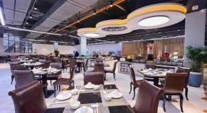 a dining room with tables and chairs in a restaurant at Shenzhen Jin Mao Yuan Hotel in Sanjiaolou