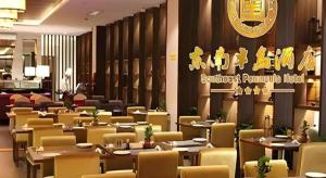a restaurant with tables and chairs and a sign on the wall at Southeast Peninsula Hotel Quanzhou in Quanzhou