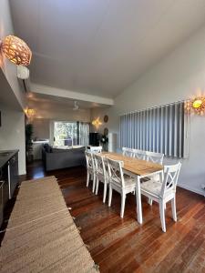 a dining room with a table and white chairs at Allure Stradbroke Resort in Point Lookout
