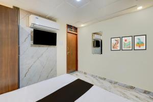a room with white walls and a door and a window at Hotel O Daraganj Ghat Prayagraj Formerly Purohit Inn in Colonelganj