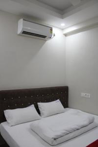 ein Schlafzimmer mit einem Bett und einer Klimaanlage an der Wand in der Unterkunft SRG Shivam Residency in Tiruvannāmalai