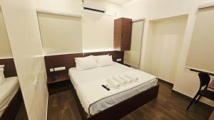 a small room with a bed with two towels on it at Chippy Inn Tharamani in Chennai +23 photos