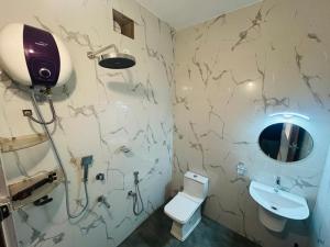 Un baño con inodoro, lavabo y espejo. en Venice Riverside, en Jāmb