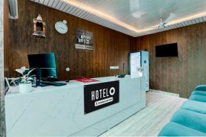a hotel lobby with a reception desk and a clock at Super Hotel O Deva Road Chinhat Formerly 24 Stays in Gomti Nagar
