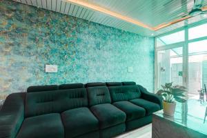 a living room with a black couch against a blue wall at Super Hotel O Deva Road Chinhat Formerly 24 Stays in Gomti Nagar