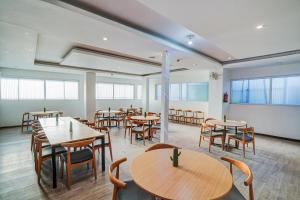 新德里Super Townhouse Yashobhoomi Formerly Hotel Grand Tashree的餐厅里有桌椅和窗户。