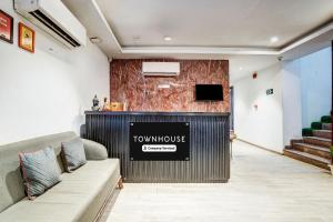 新德里Super Townhouse Yashobhoomi Formerly Hotel Grand Tashree的大堂配有电视,沙发位于客房内