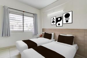 a bedroom with two beds and a window at Super Hotel O KSR Bengaluru City Junction Formerly Gurudev Residency in Bengaluru
