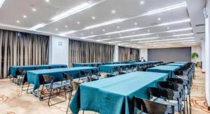 a conference room with blue tables and chairs and a screen at James Joyce Coffetel·Anyang Text Museum in Anyang
