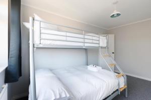 a bedroom with two bunk beds with a ladder at Spacious 2-Bedroom Flat Near Rottingdean Beach & Windmill in Brighton & Hove