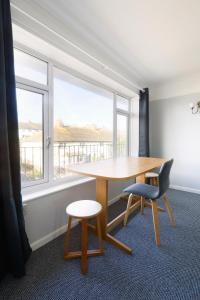 a table and two chairs in a room with a window at Spacious 2-Bedroom Flat Near Rottingdean Beach & Windmill in Brighton & Hove